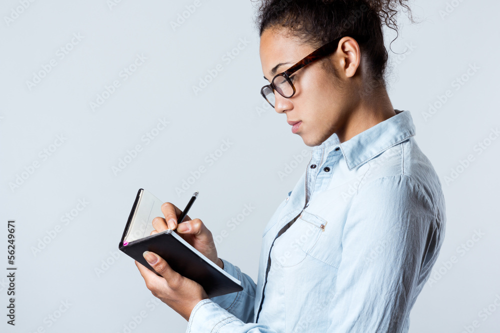 Young black woman taking notes at home
