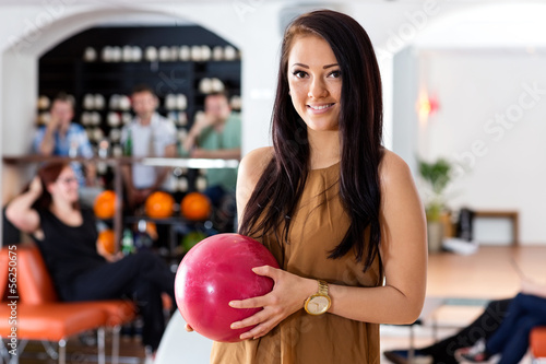 Happy Woman Holding Bowling Ball in Club