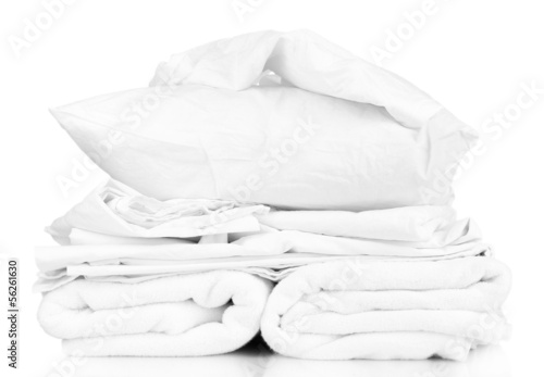 Canvas Print Stack of rumpled bedding sheets isolated on white