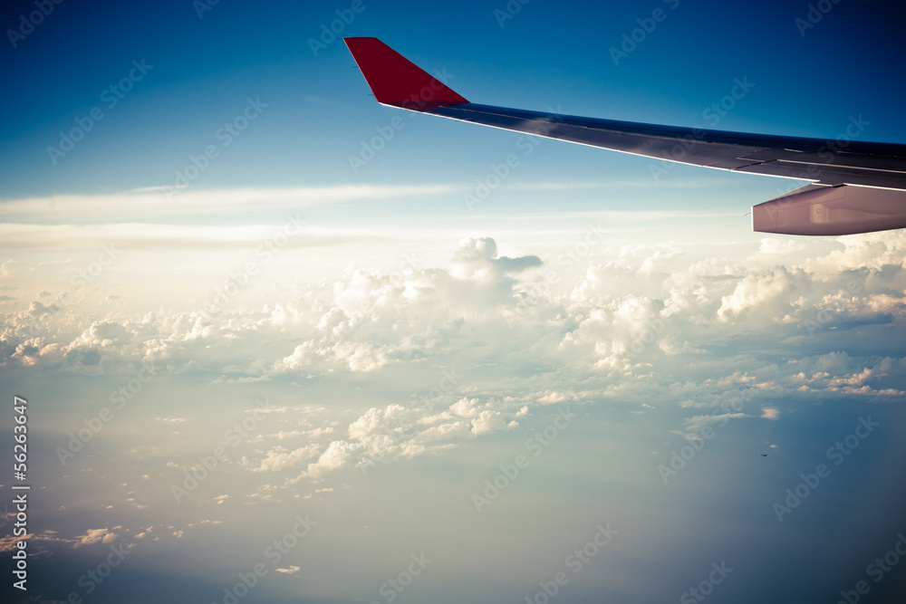 Fototapeta premium Clouds and sky as seen through window of an aircraft at sunset