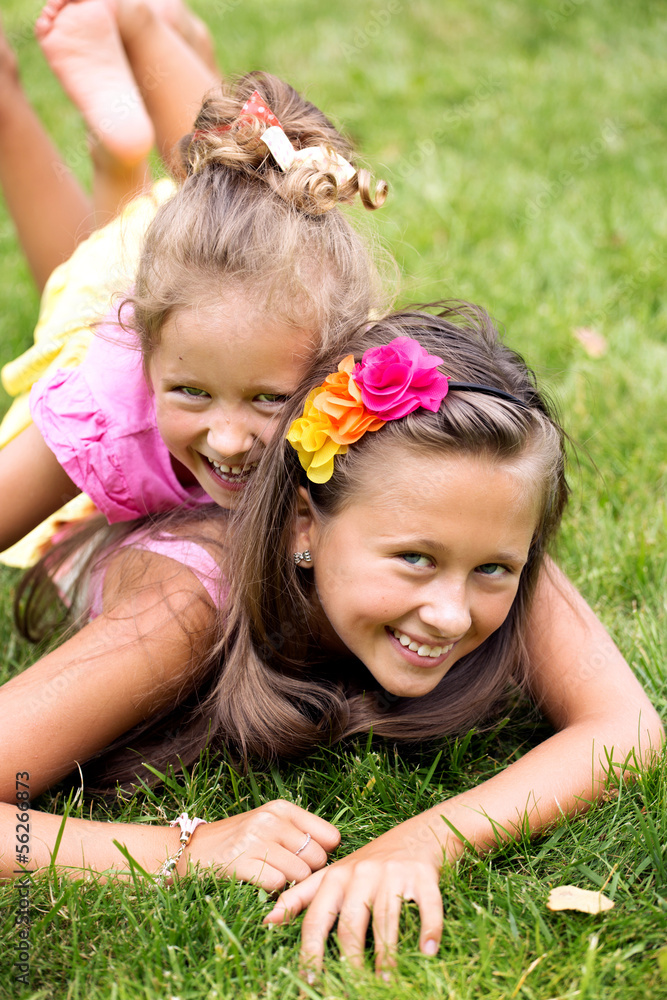 Two smiling girls playing on the summer grass Two smiling girls playing on the summer grass