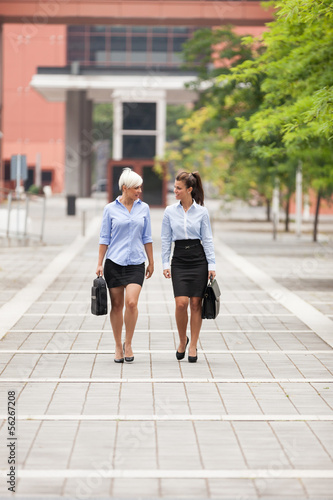 Two businesswoman are walking on the street