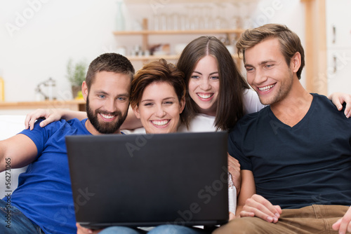 freunde schauen lachend auf laptop