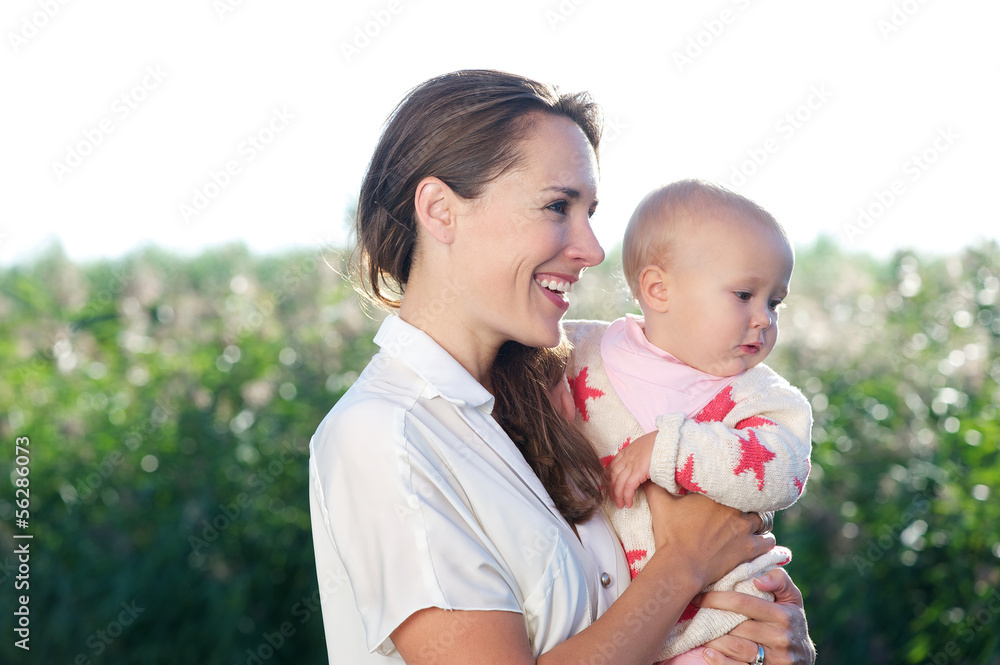 Beautiful mother smiling and holding cute baby Beautiful mother smiling and holding cute baby
