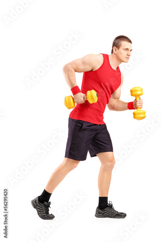 Full length portrait of a muscular athletic man lifting dumbbell