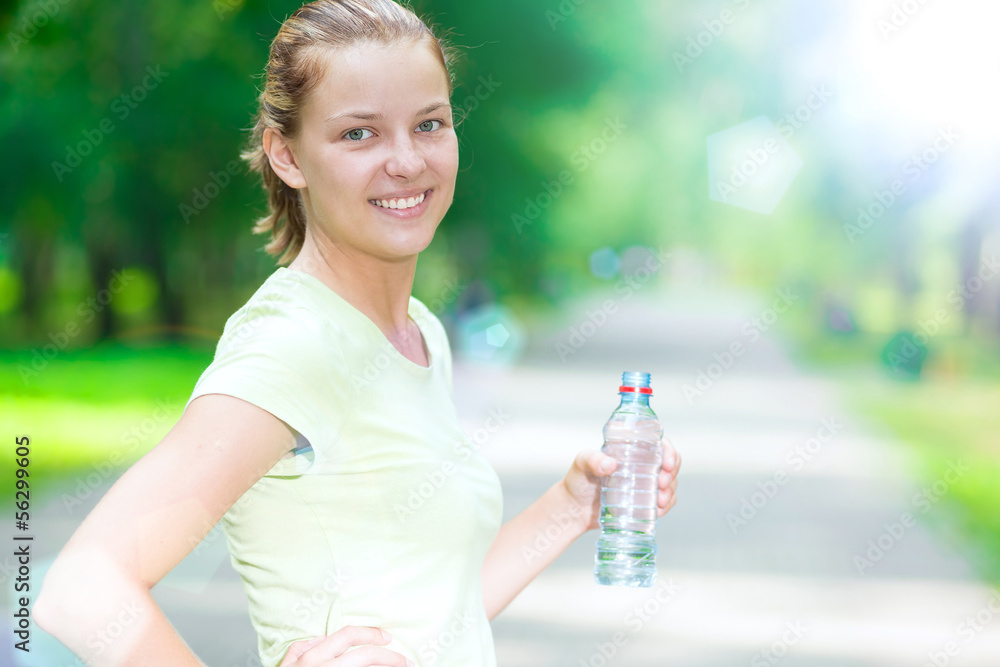 Woman drinking cold mineral water from a bottle after fitness ex Woman drinking cold mineral water from a bottle after fitness ex