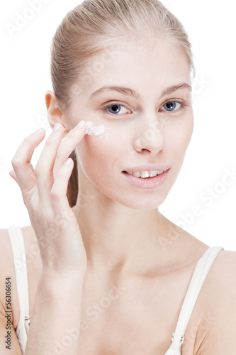 young blond woman applying facial creme