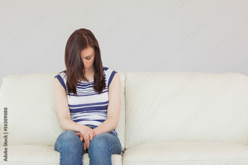 Depressed girl sitting on a sofa