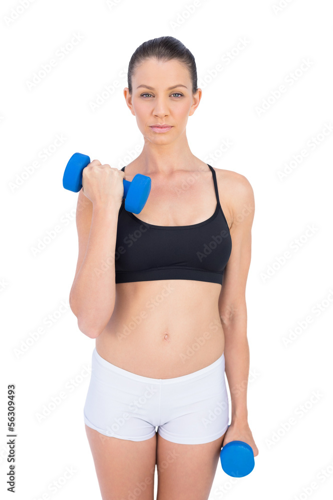 Peaceful sporty brunette working out with dumbbells Peaceful sporty brunette working out with dumbbells