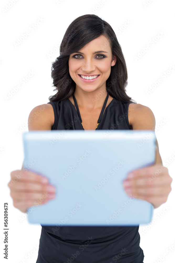 Happy elegant brown haired model holding tablet in front of her Happy elegant brown haired model holding tablet in front of her