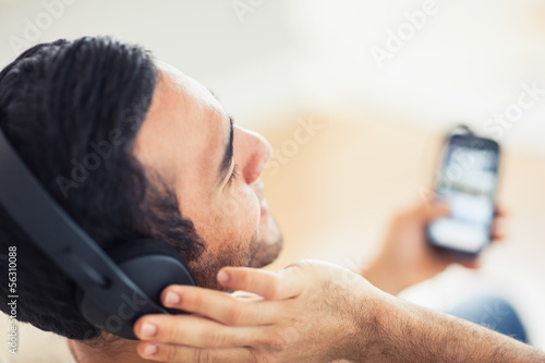 Close up on handsome man listening to music on his smartphone