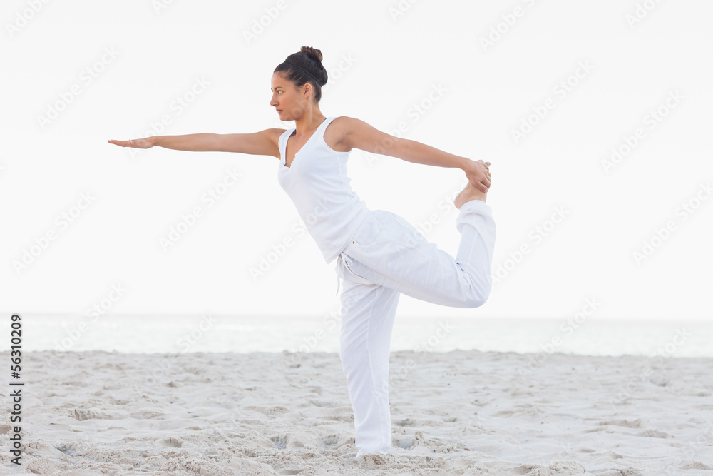 Brunette woman wearing all white stretching in yoga pose Brunette woman wearing all white stretching in yoga pose