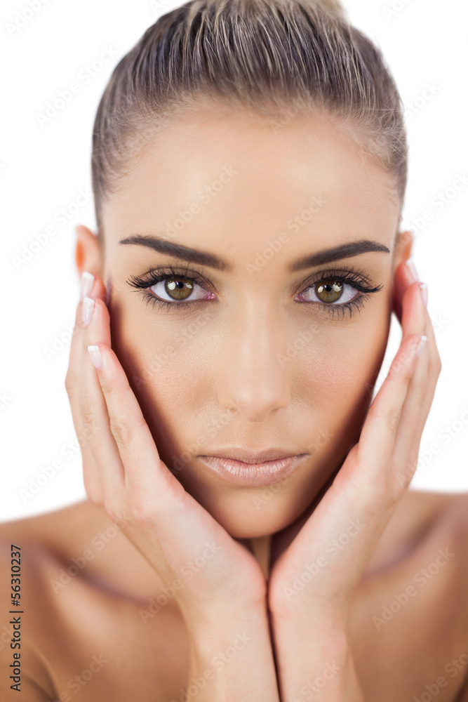 Beautiful woman holding her head and looking at camera Beautiful woman holding her head and looking at camera