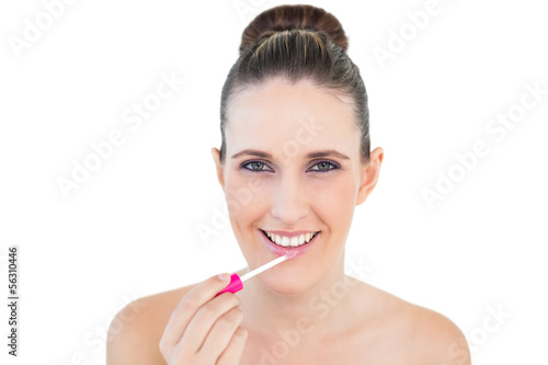 Smiling attractive woman applying lip gloss