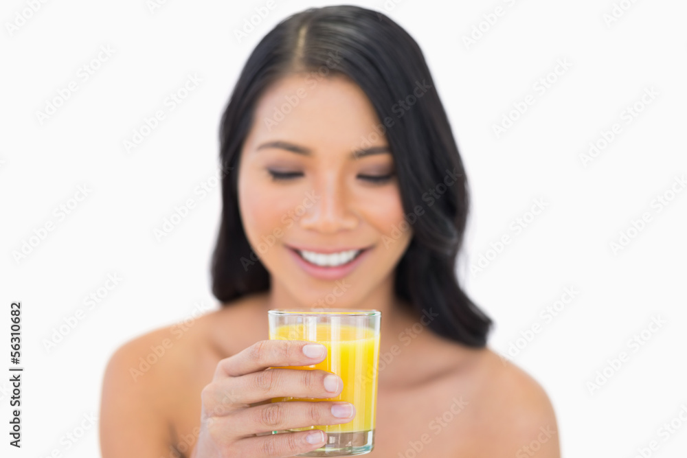 Cheerful sensual nude model drinking orange juice Cheerful sensual nude model drinking orange juice