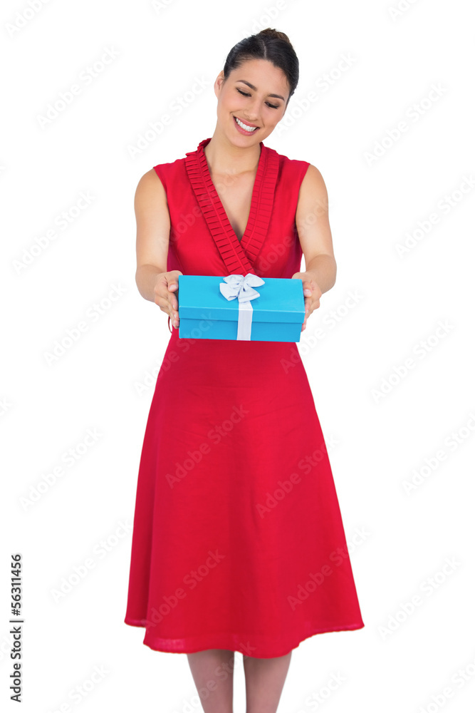 Smiling glamorous model in red dress offering present Smiling glamorous model in red dress offering present