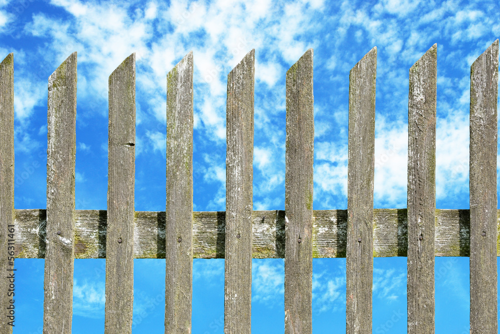 old wooden fence with cloudy sky