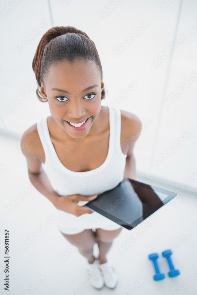 High angle view of happy sporty woman holding tablet High angle view of happy sporty woman holding tablet