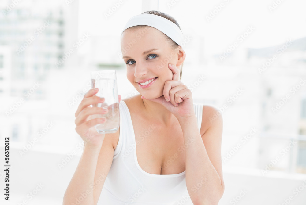 Pensive pretty sportswoman holding a glass of water Pensive pretty sportswoman holding a glass of water