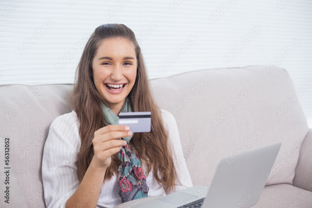 Smiling young model using her credit card to buy online Smiling young model using her credit card to buy online