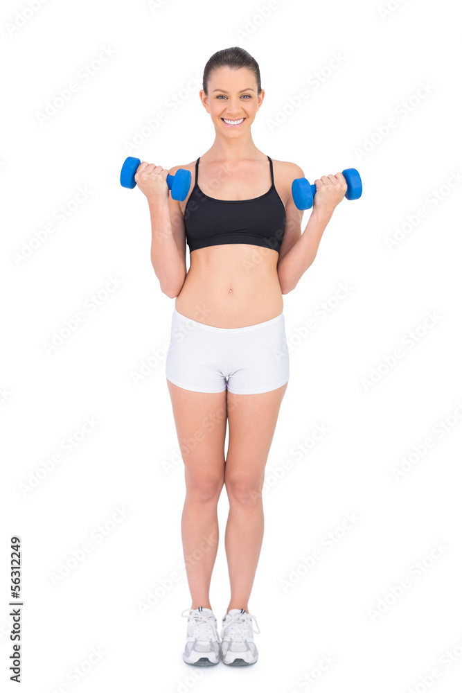 Smiling fit woman working out with dumbbells Smiling fit woman working out with dumbbells