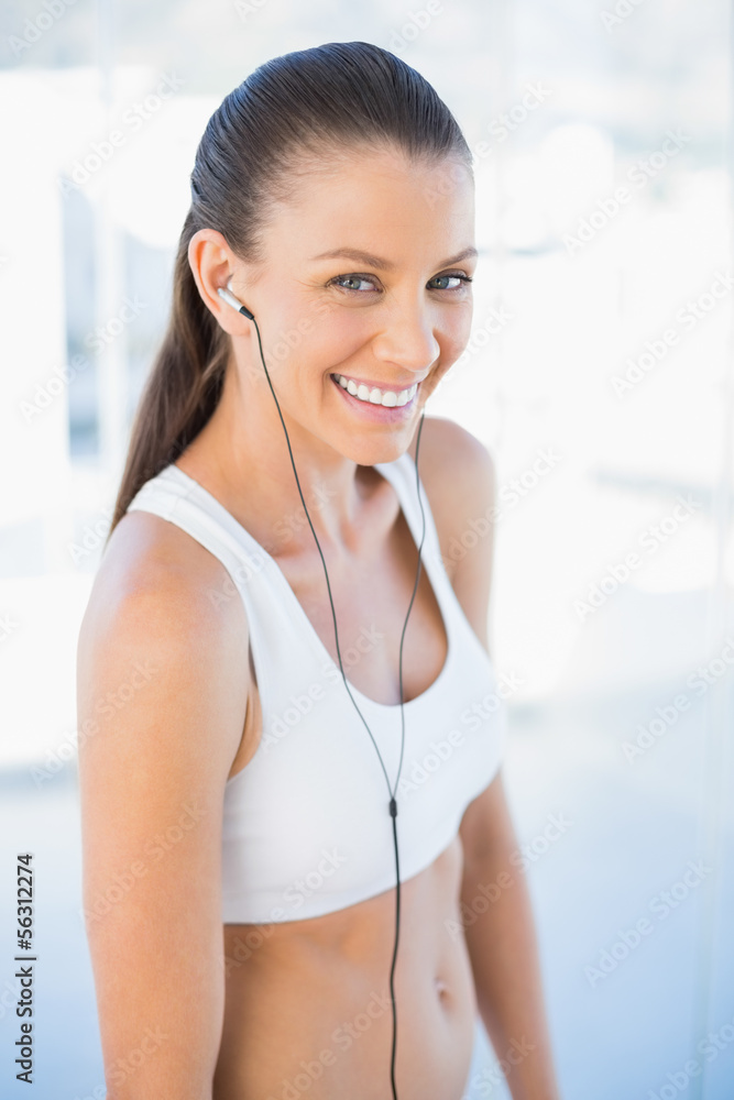 Laughing woman in sportswear listening to music