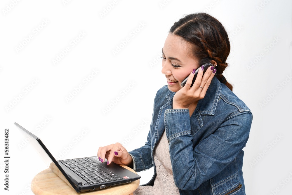 Woman speaking mobile phone and using computer Woman speaking mobile phone and using computer