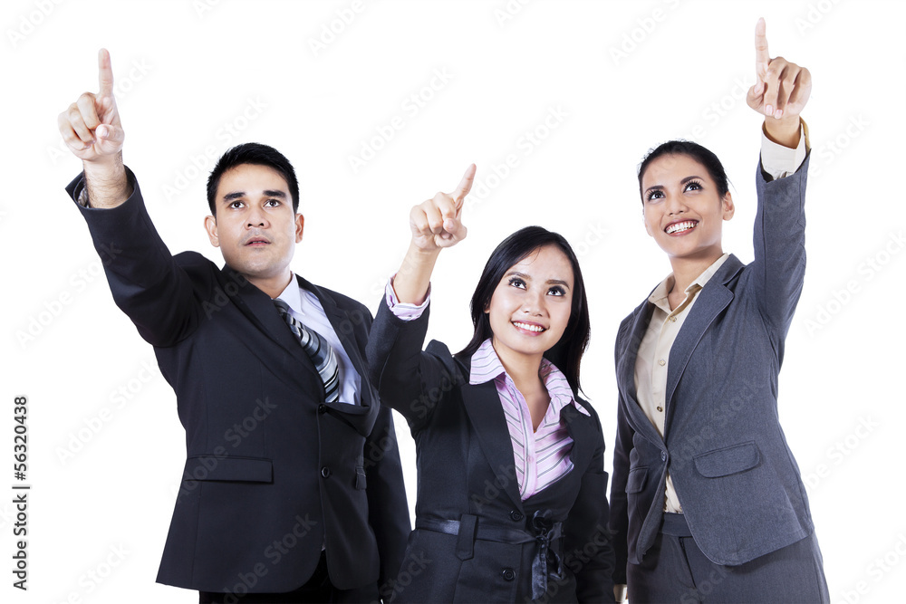Business people standing together pointing and looking up Business people standing together pointing and looking up