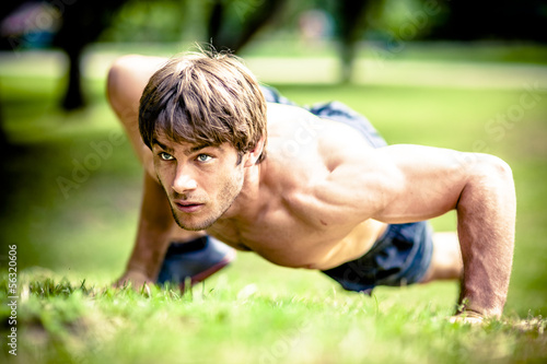 Obraz na płótnie young athletic man doing workout in park