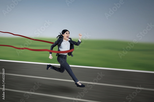 Businesswoman passing finishing line