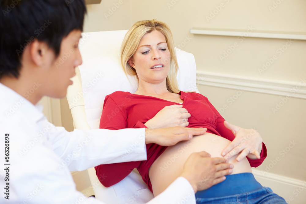 Fototapeta premium Pregnant Woman Being Given Ante Natal Check By Doctor