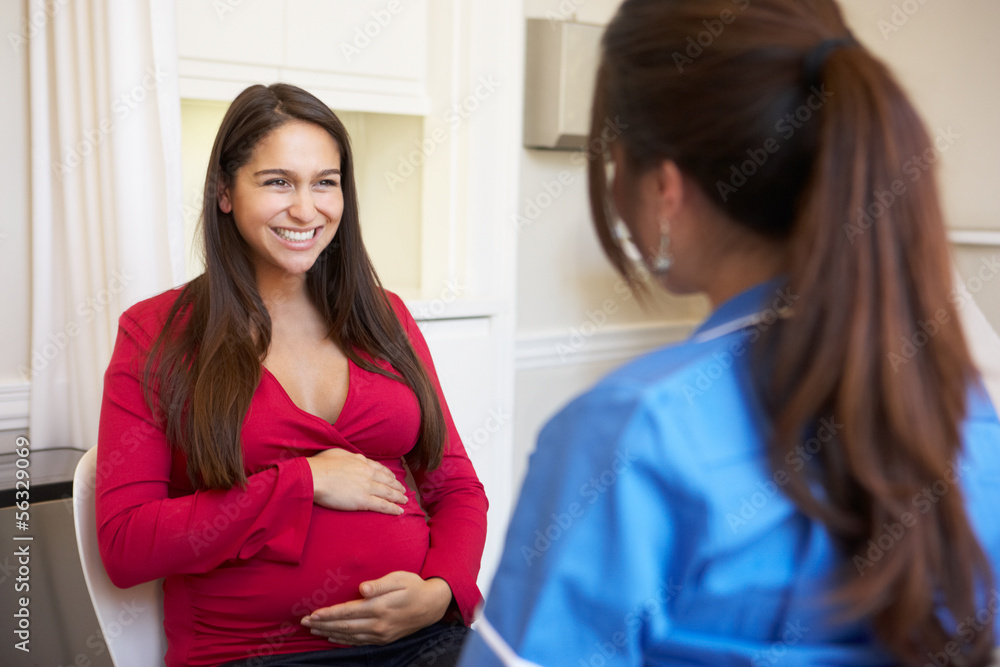 Pregnant Woman Meeting With Nurse In Clinic Pregnant Woman Meeting With Nurse In Clinic