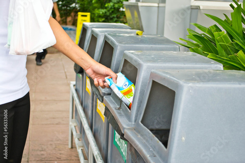 People throwing rubbish in a trash bin