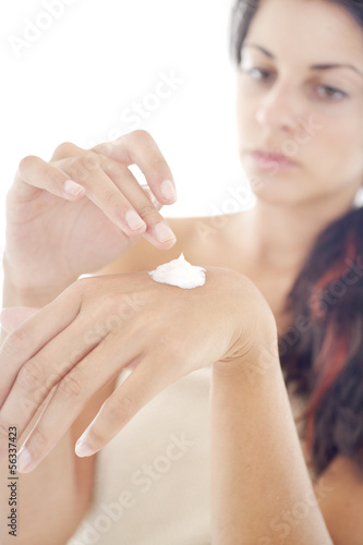 Young woman applies cream on her hands