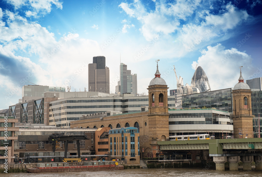 City of London with clouds, financial center and Canary Wharf at
