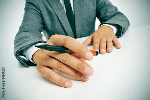 man in suit with a pen in his hand