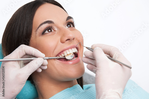 Patient at dentist office. Close-up of cheerful young woman sitt