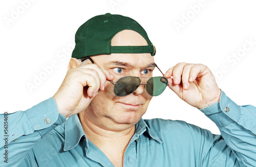 a man in a baseball cap and dark glasses.