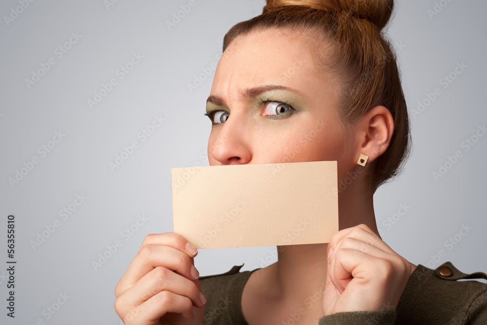 Cute girl holding white card at front of her lips with copy spac Cute girl holding white card at front of her lips with copy spac