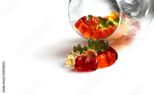 Fruit gummy bear candies falling from a wine glass