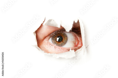 Eye looking through a hole in a paper