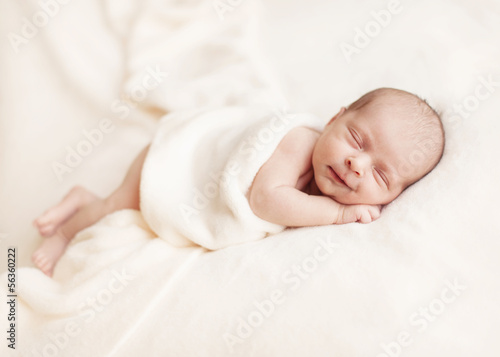 Newborn baby girl asleep on a blanket.