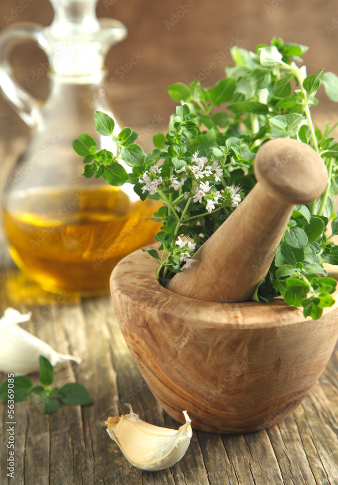 Oregano herb in wooden mortar and pestle.