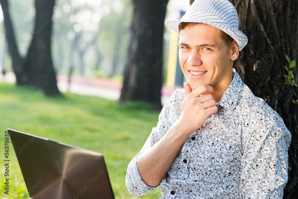young man working in the park with a laptop young man working in the park with a laptop
