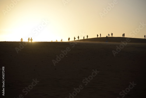 Group of people silhouetted against setting sun