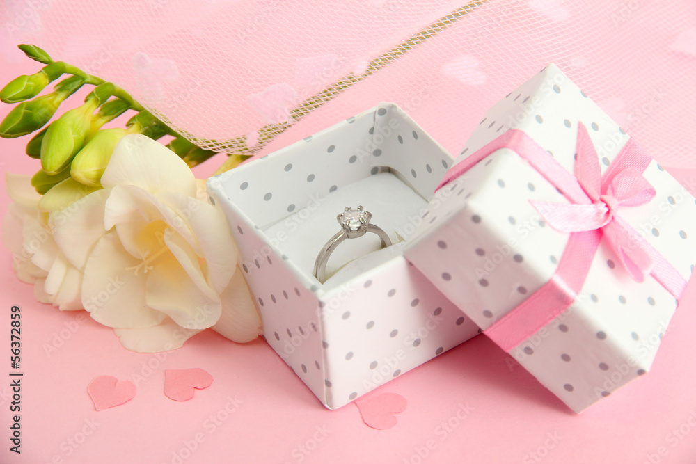 Beautiful box with wedding ring and flower on pink background Beautiful box with wedding ring and flower on pink background