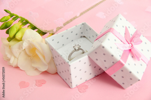 Fototapeta Naklejka Na Ścianę i Meble -  Beautiful box with wedding ring and flower on pink background