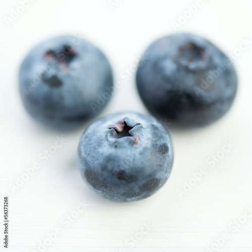 Macro shot of ripe blueberries on white wooden background