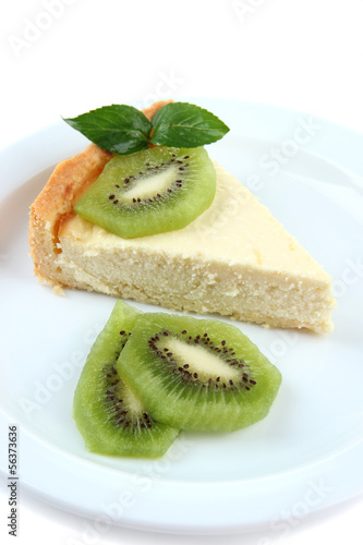 Slice of cheesecake with kiwi fruit on plate, isolated on white