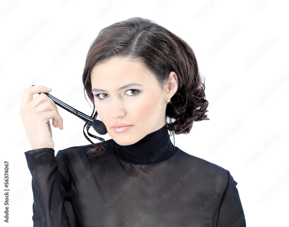 Obraz premium Beautiful woman with makeup brush near her face -
